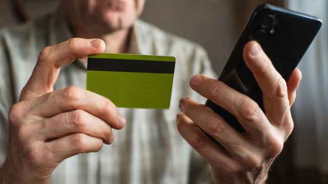 Imagen de un hombre con un teléfono inteligente y una tarjeta de crédito.