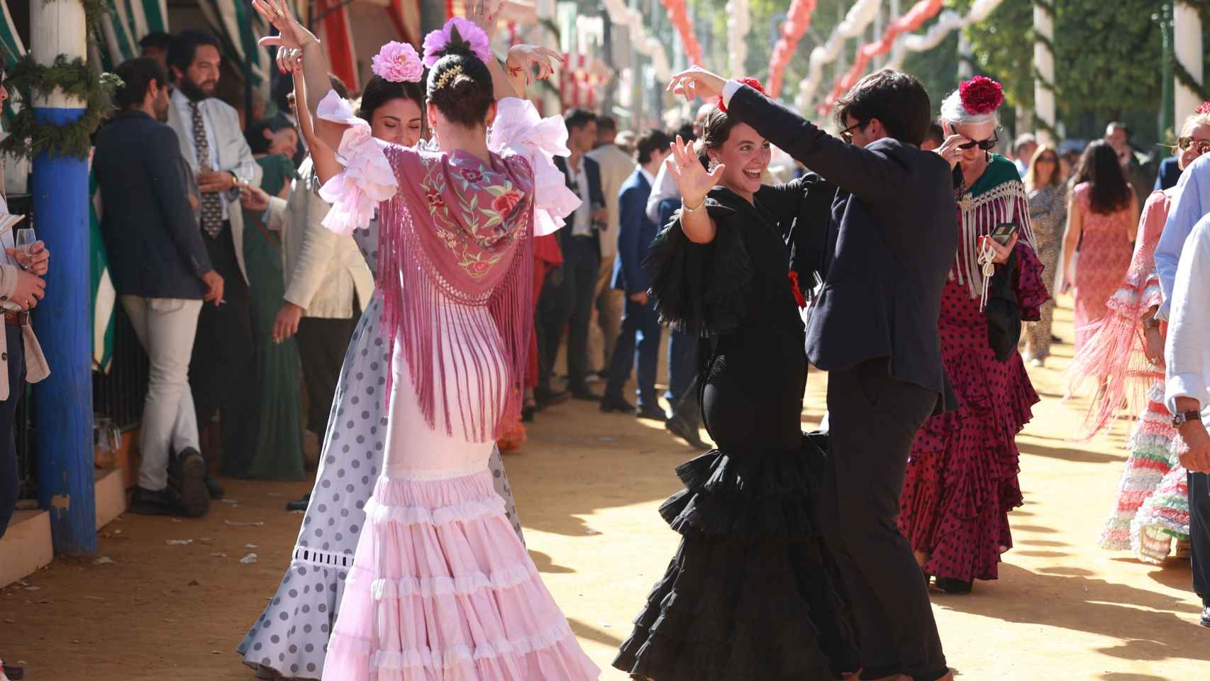 Varias personas bailan sevillanas en el Real de la Feria de Abril.