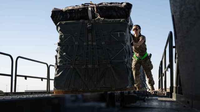 Una militar estadounidense carga ayuda humanitaria en un avión de transporte.
