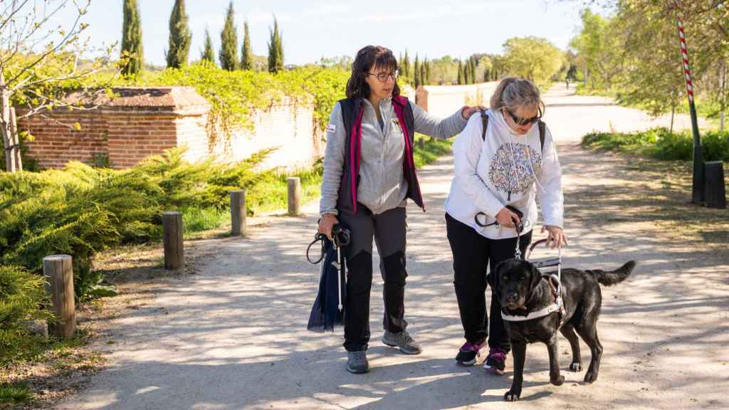 Conchi pasea con su perra, acompañada de la instructora Raquel Blesa.