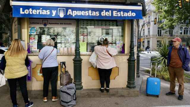 Varias personas en una administración de Lotería de Málaga.