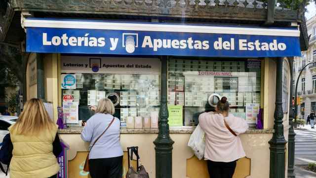 Varias personas en una administración de Lotería de Málaga.