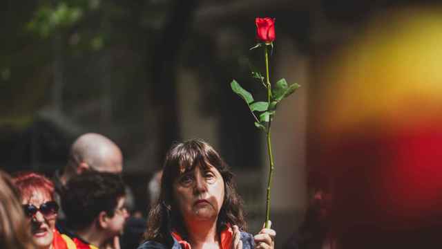 Una señora compra una rosa en la floristería para sacarla a la manifestación de Ferraz.