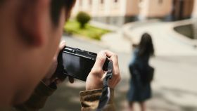 Una persona grabando a otra en la calle.