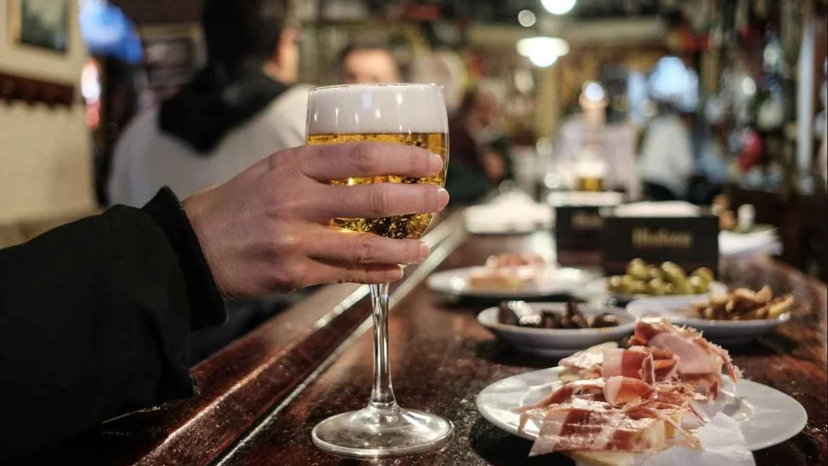 Cerveza y tapa en la barra de un bar.