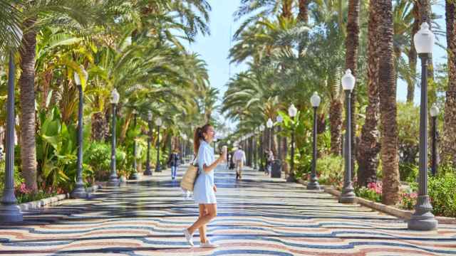 Una joven paseando por el paseo de la Explanada de Alicante.