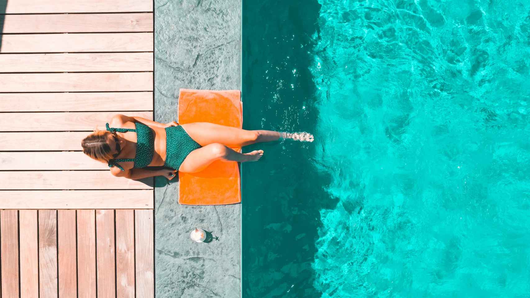 Mujer en la piscina tomando el sol.