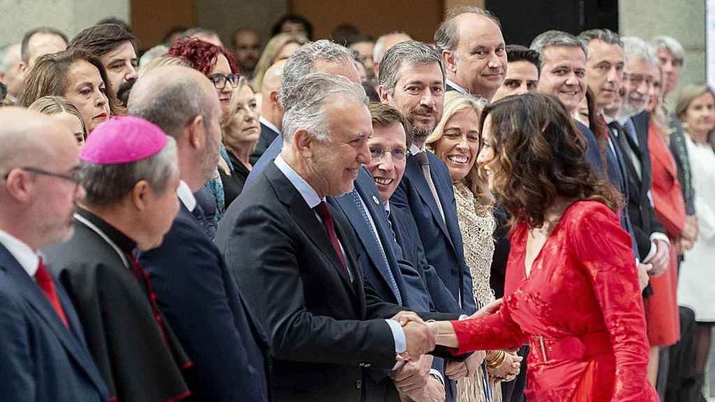 La presidenta de la Comunidad de Madrid, Isabel Díaz Ayuso, saluda al ministro de Política Territorial y Memoria Democrática, Ángel Víctor Torres, a su llegada a la entrega de Grandes Cruces de la Orden del Dos de Mayo