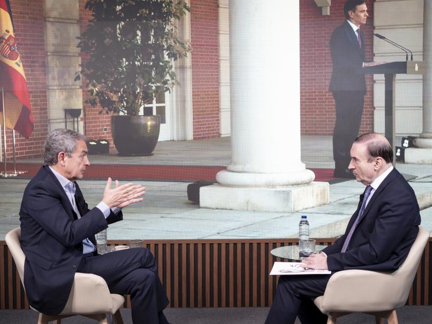 Rodríguez Zapatero y Pedro J. Ramírez, en un momento de la entrevista. De fondo, la comparecencia de Pedro Sánchez en la que anunció que no dimitiría.