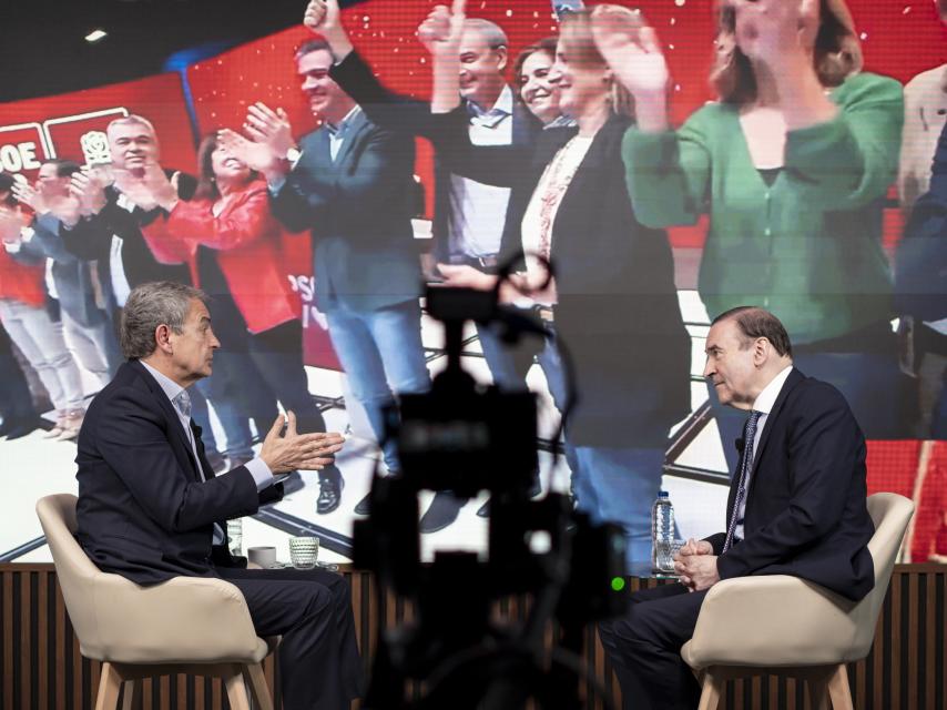 Un momento de la entrevista entre Rodríguez Zapatero y Pedro J. Ramírez, con una imagen de fondo de la campaña del PSOE de las últimas elecciones generales.