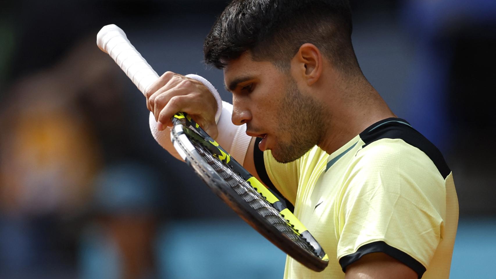 Carlos Alcaraz se lleva la mano a la cara durante un partido en el Mutua Madrid Open.