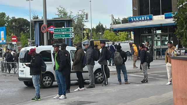 Migrantes hacen fila en la Plaza Elíptica de Madrid esperando a que algún empresario les contrate por horas.