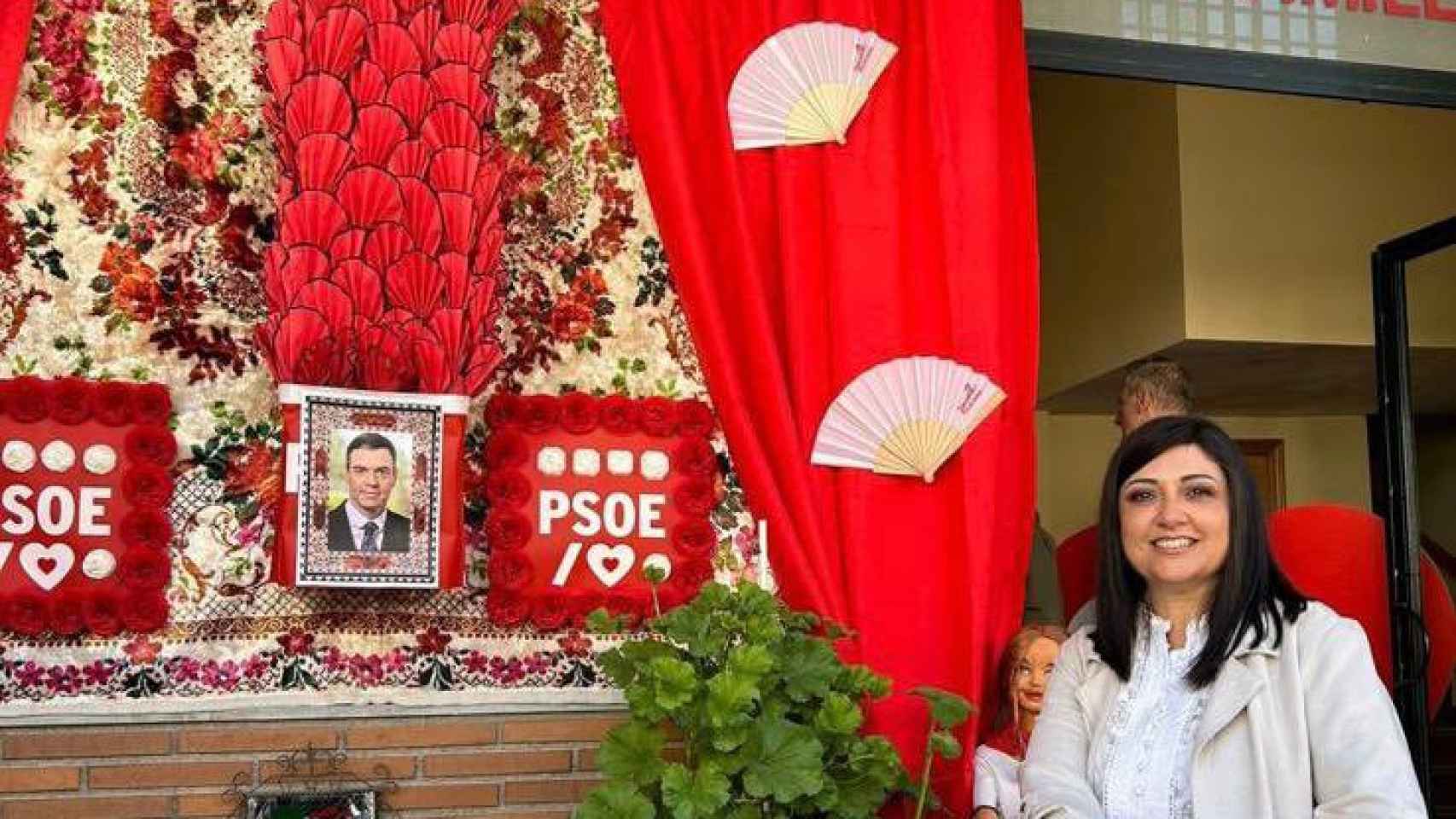 La alcaldesa de Armilla, Loli Cañavate, posa con la cruz de mayo que ha dedicado el PSOE a Pedro Sánchez.