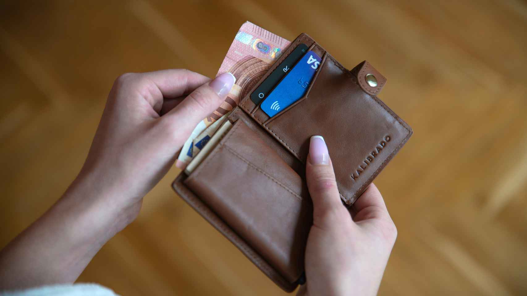 Imagen de archivo con de una cartera con dinero en efectivo y tarjetas de crédito.