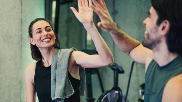 Pareja chocando los cinco en un gimnasio.