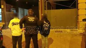 Un agente de la Policía Local de Murcia con los padres del niño cuando fueron puestos a disposición de la Policía Nacional, durante madrugada de este domingo,