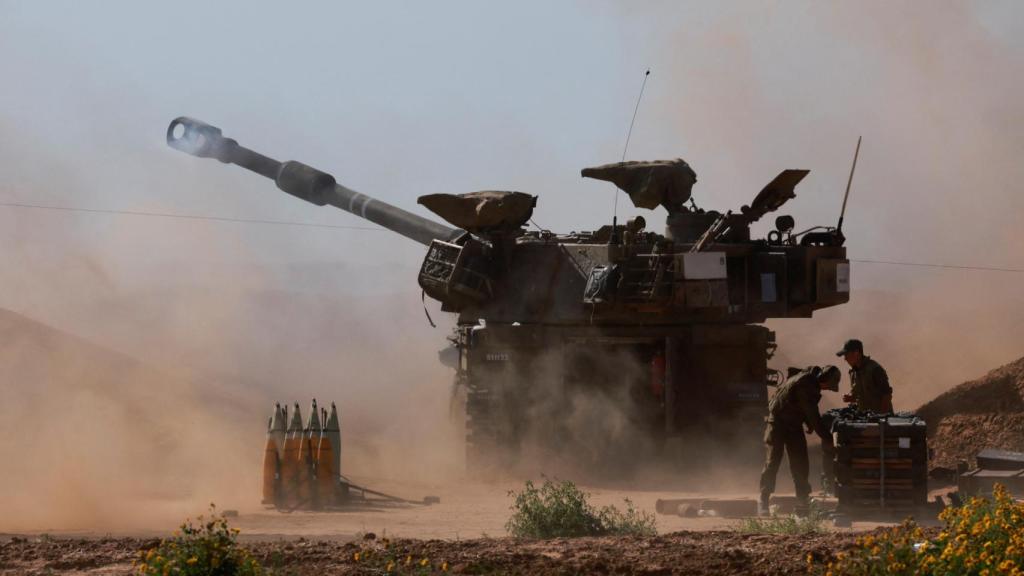 Un vehículo militar israelí dispara cerca de la frontera con Gaza, este miércoles.