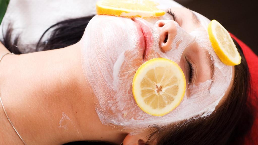 Mujer con una mascarilla de limón sobre la cara.
