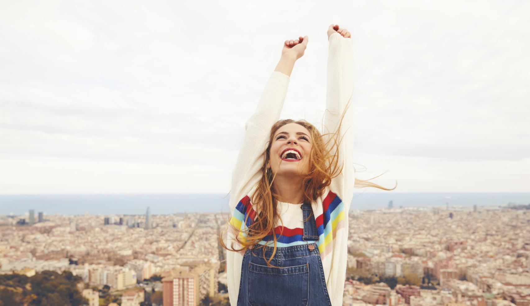 Mujer feliz con la ciudad detrás.