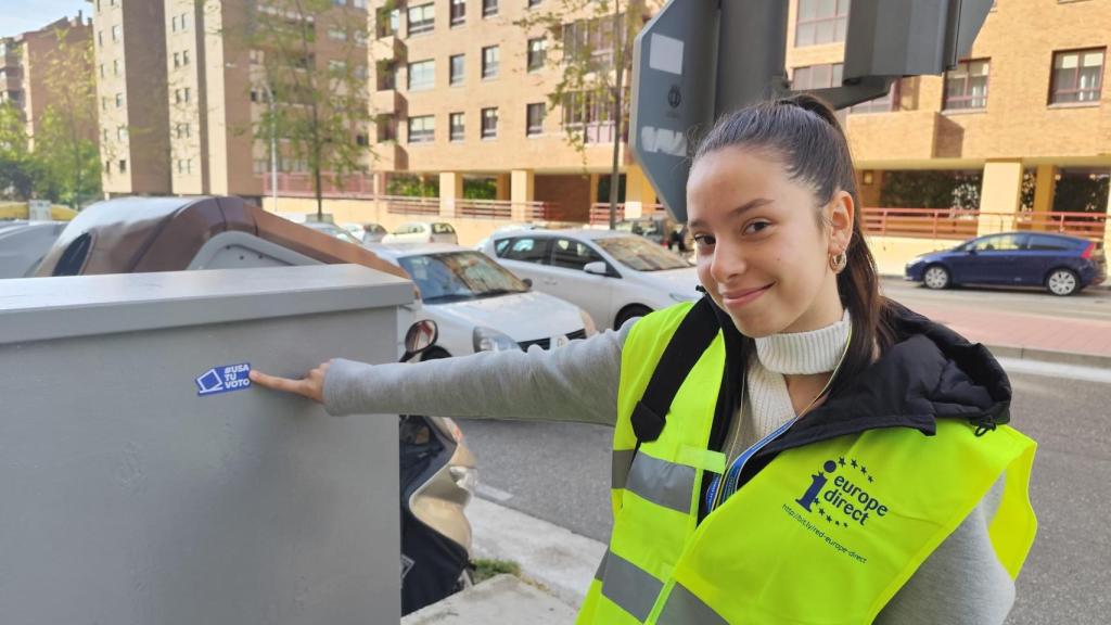 Una alumna del IES Parquesol pega una pegatina para promover el voto