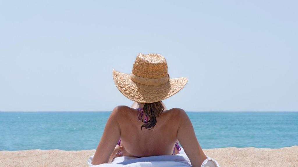 Mujer tomando el sol en la orilla del mar.