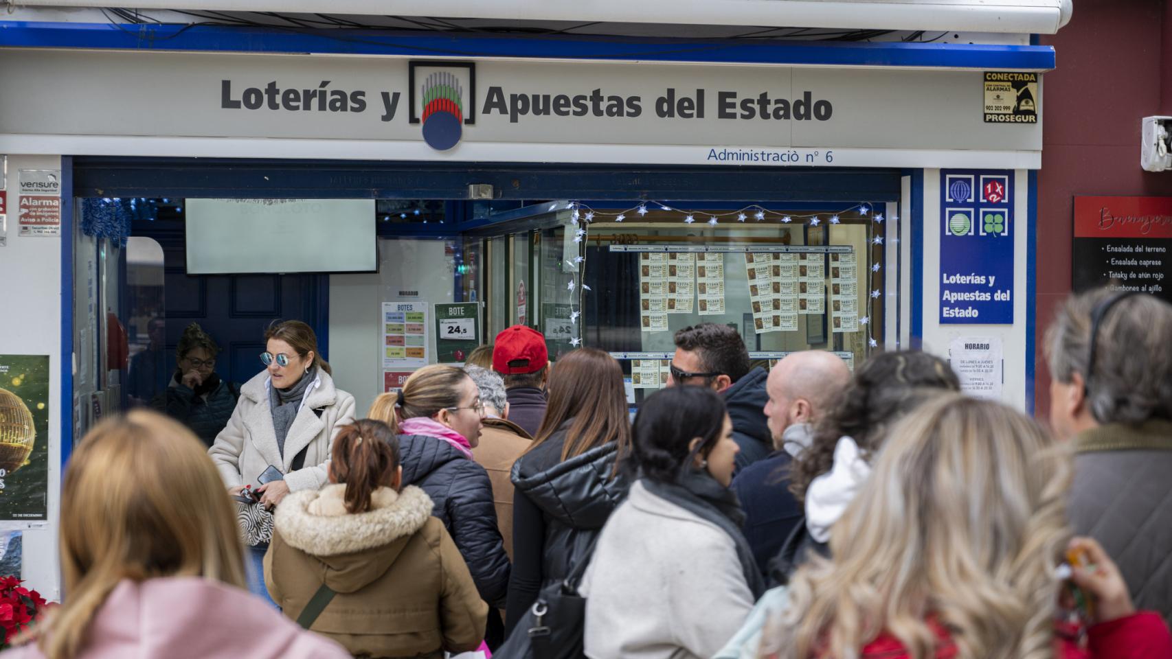 Varias personas comprando lotería en una administración.