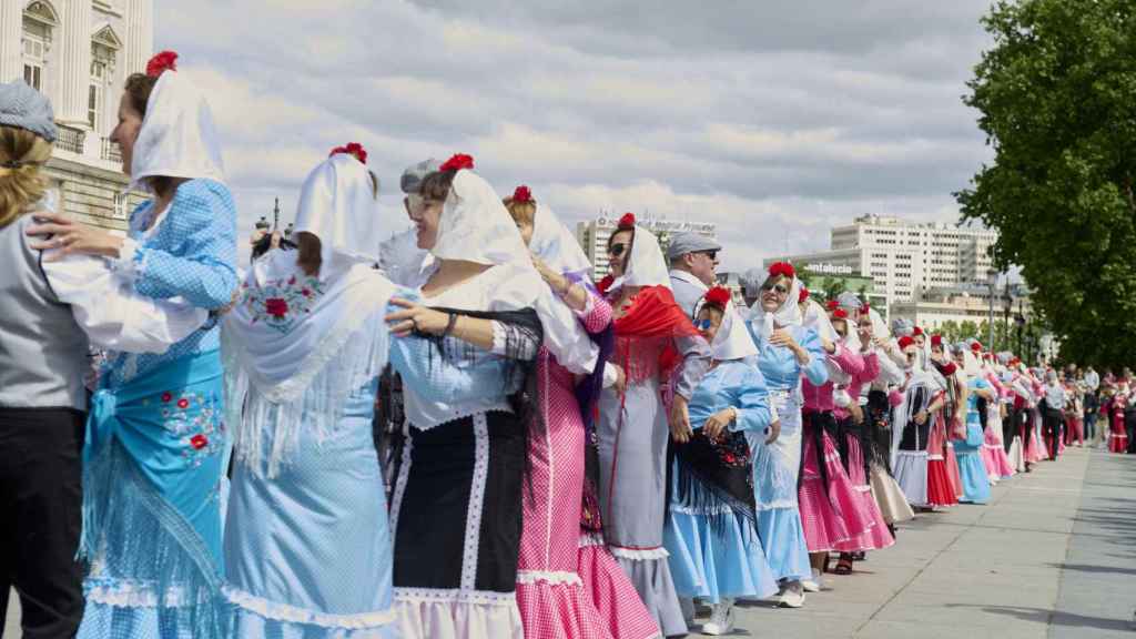Personas vestidas de chulapo y bailando por Madrid en las Fiestas de San Isidro.