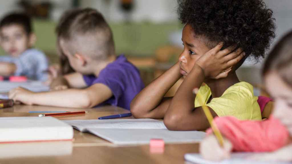 Imagen de archivo de un niño tapándose los oídos en un aula de colegio (iStock).