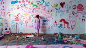 Imagen de archivo de una niña pintando un mural (iStock).