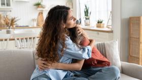 Imagen de archivo de una madre arropando a su hija (iStock).