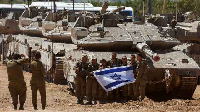 Soldados israelíes posan junto a un tanque cerca de la frontera entre Israel y Gaza, este jueves.