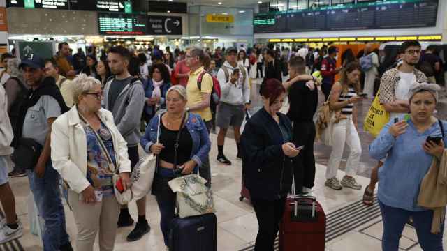Decenas de viajeros esperan en la estación de Sans en Barcelona.
