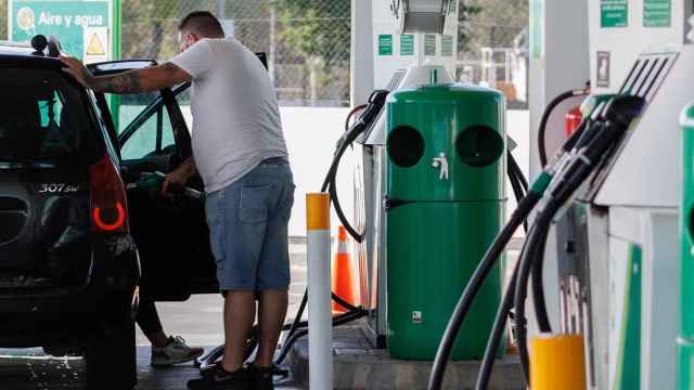Un hombre echa carburante a su vehículo en una gasolinera.