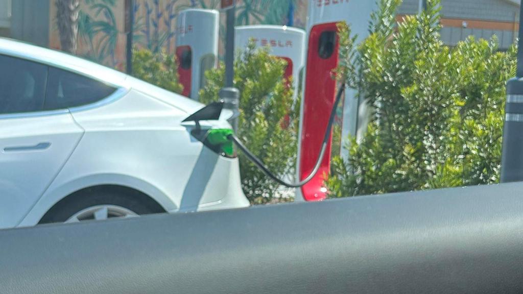 Un coche eléctrico de Tesla usando el truco de la toalla en el cargador