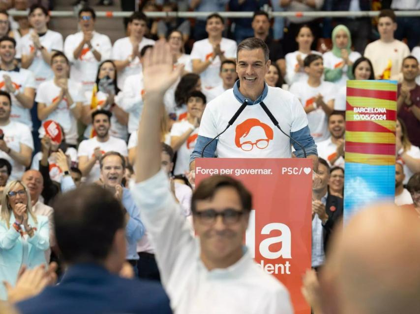 Salvador Illa, en primer plano, saluda a la multitud mientras Pedro Sánchez pide el voto para él, en el cierre de campaña del PSC el pasado viernes en Barcelona.