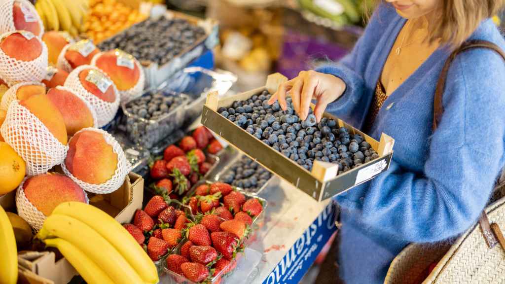 Una mujer comprando en la frutería del mercado.