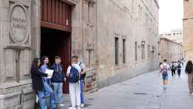 Estudiantes esperan en la puerta de la Universidad Pontificia de Salamanca