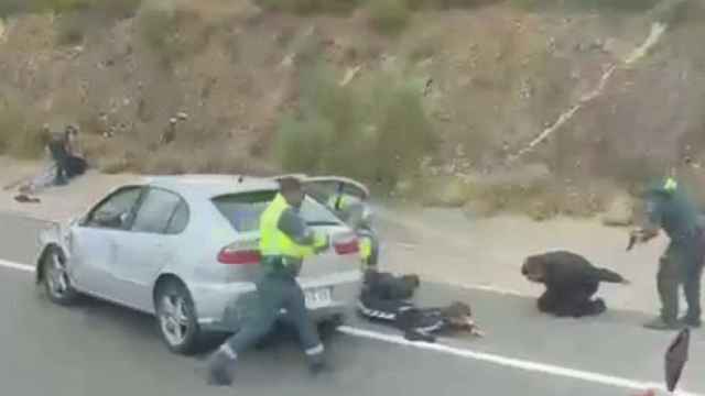 Los guardias civiles, este martes, apuntando con sus armas reglamentarias a los supuestos atracadores de Cáceres.