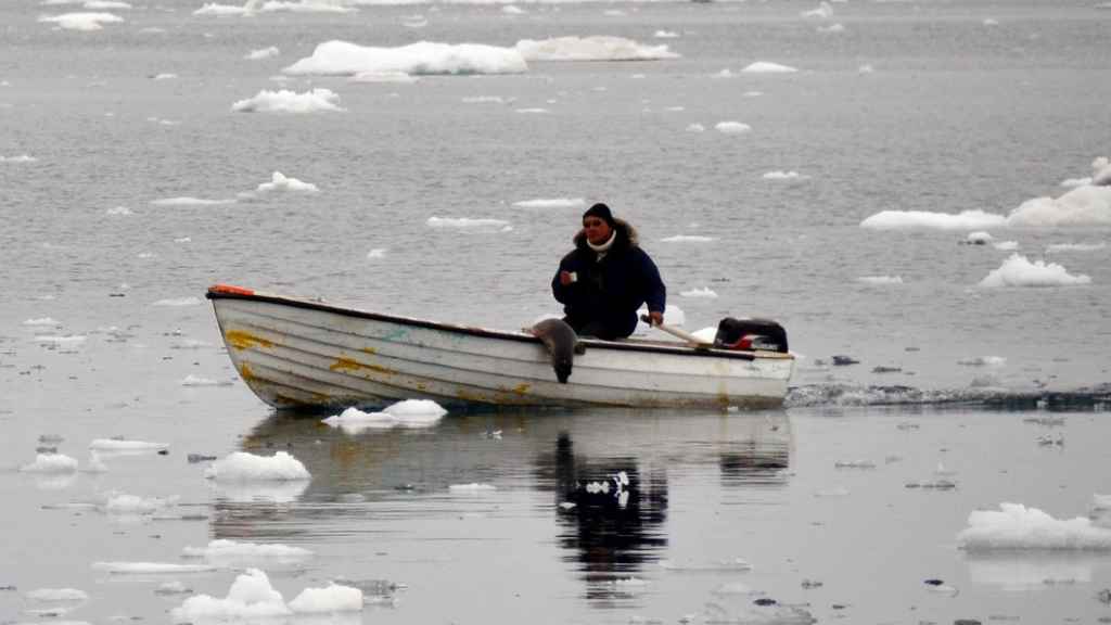 Un inuit en una embarcación cruza un paisaje helado, en Groenlandia.