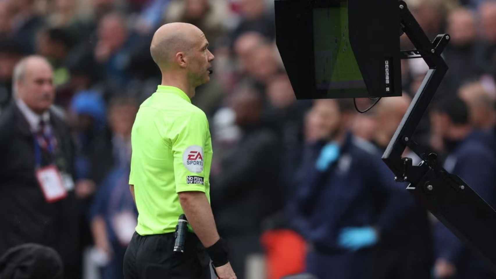 Un árbitro inglés revisa una acción en el VAR durante un partido de la Premier League.