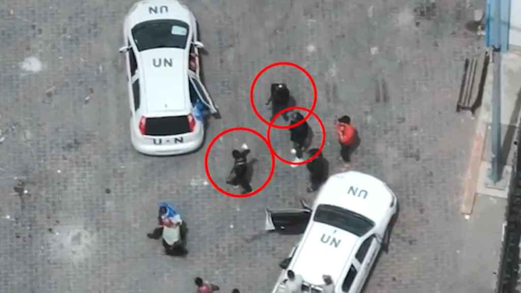 Varios hombres presuntamente miembros de Hamás situados alrededor de vehículos de la ONU en Gaza.