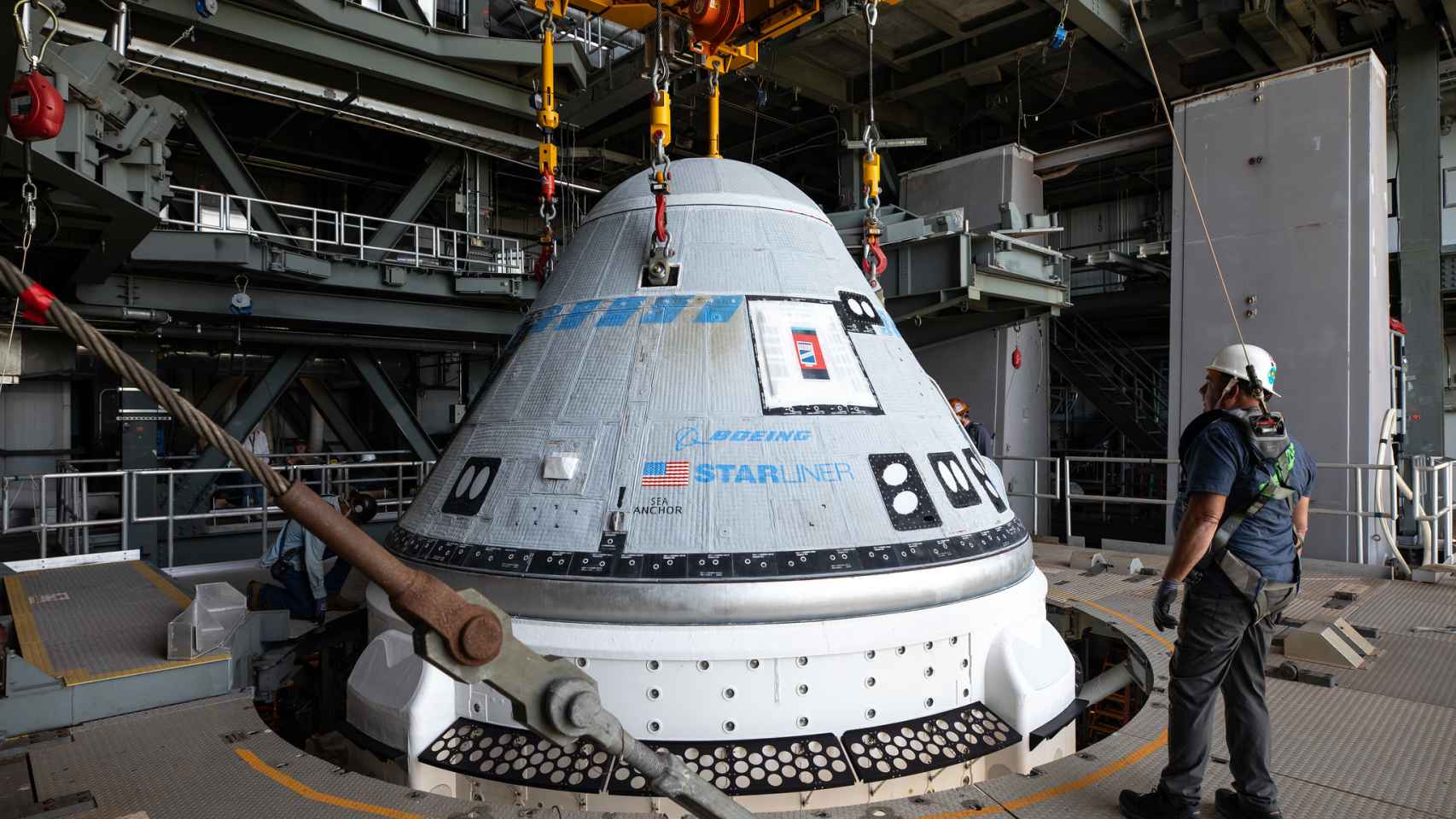 Técnicos trabajando en la integración de la nave espacial Starliner en el cohete