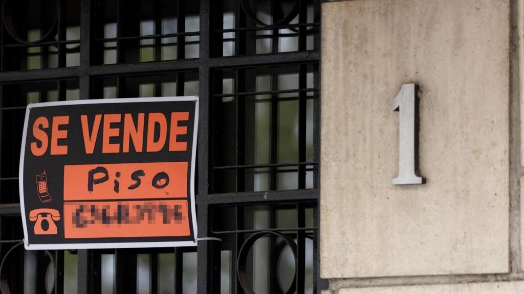 Vista de un cartel de ‘Se vende’ en un portal de un edificio