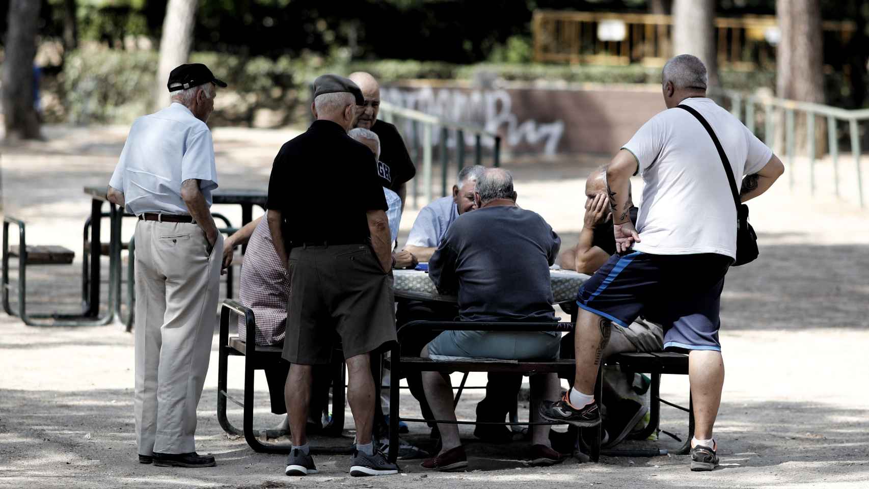 Varios hombres jugando al dominó en la calle.