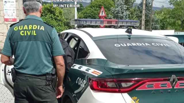 Un agente y un vehículo de la Guardia Civil.