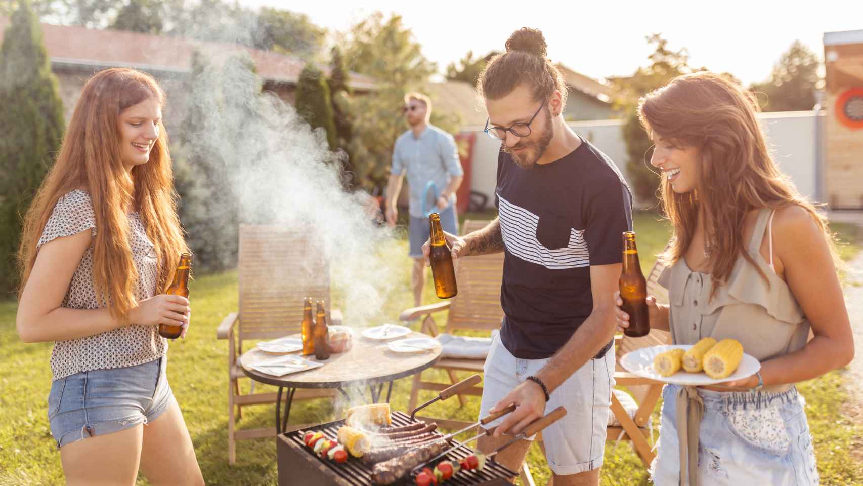 Un grupo de amigos haciendo una barbacoa en un jardín