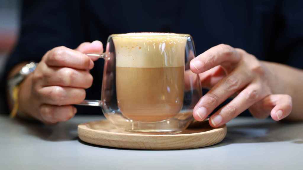 Una persona se dispone a tomar un café con leche