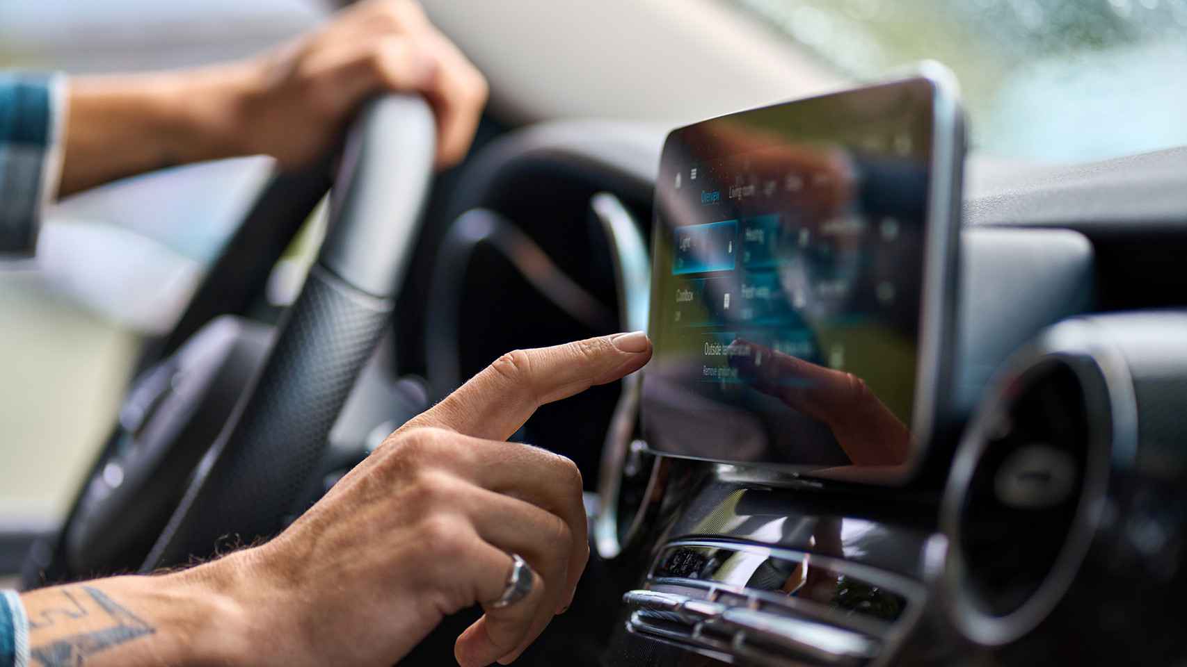 Un conductor tocando la pantalla de su coche