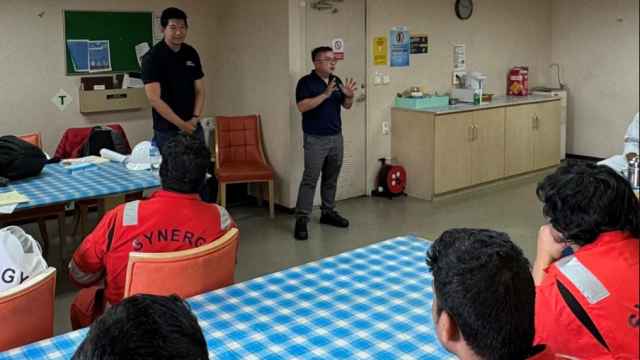 Miembros de la Organización de Marineros de Singapur y del Sindicato de Oficiales Marítimos de Singapur, hablan con los marineros a bordo del Dali cuatro semanas después de que el carguero se estrellara contra un puente en Balitmore.