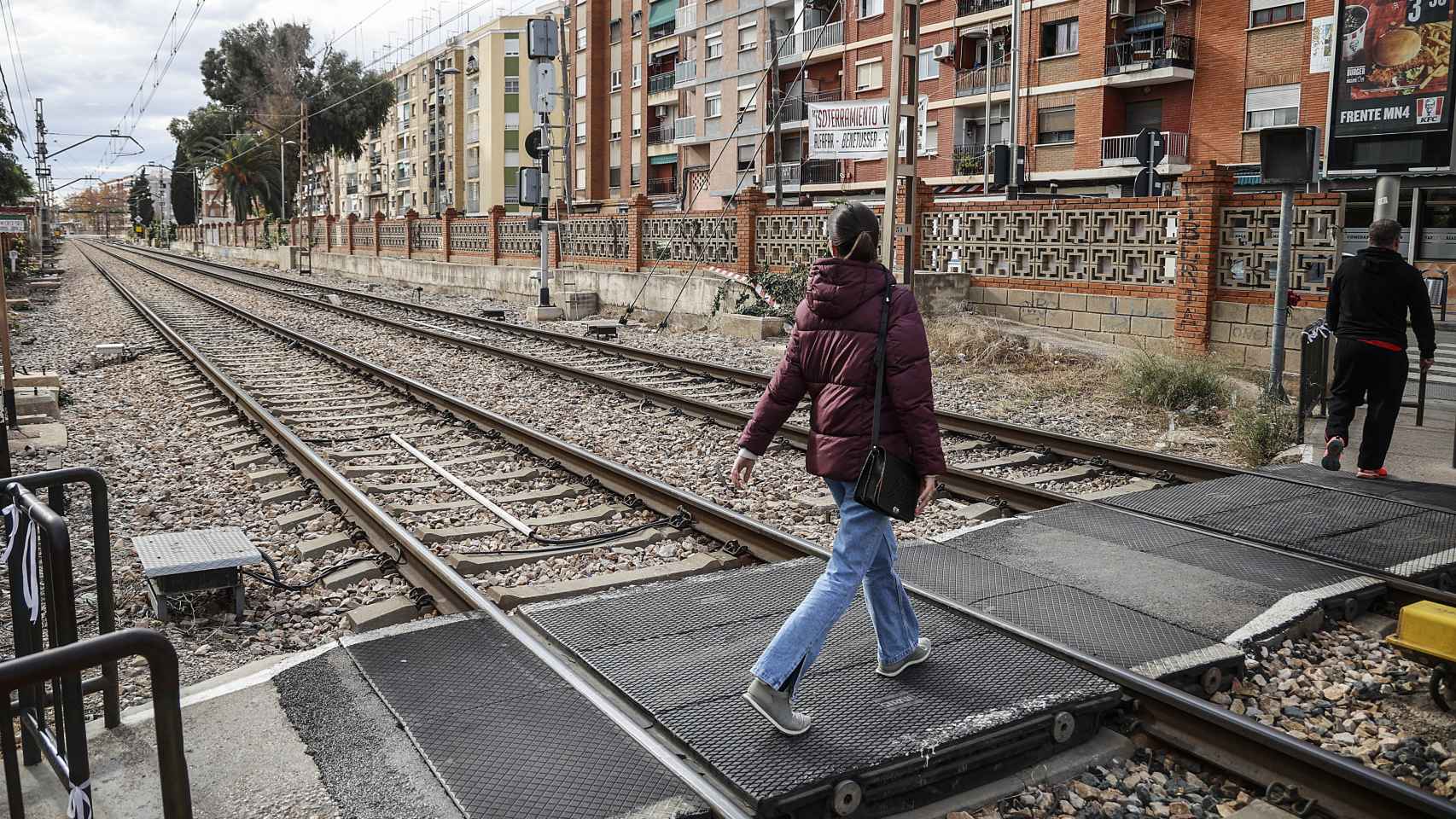 Varias personas cruzan el paso a nivel de Alfafar